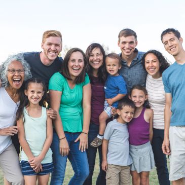 A diverse happy family posing together outdoors.