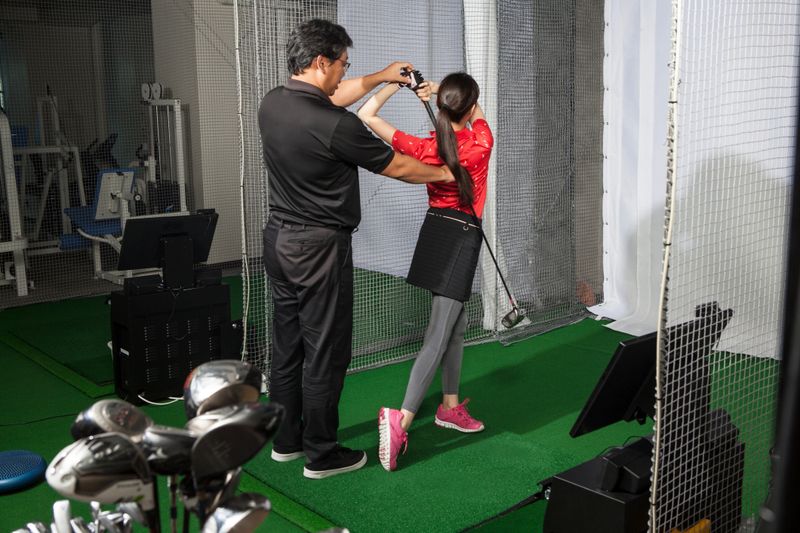 A woman taught me as a man teaching golf at a golf studio.