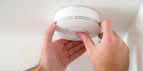 Electrician installing a home or business smoke detector Electric Repair