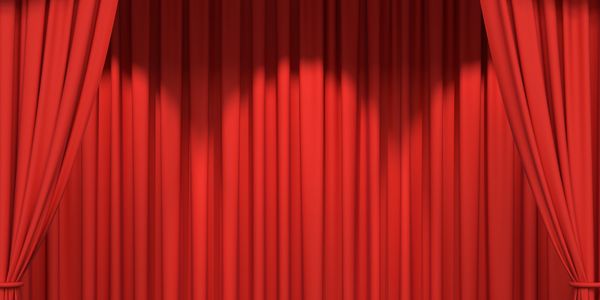 Closed red stage curtains with gold trim, ready for a performance.