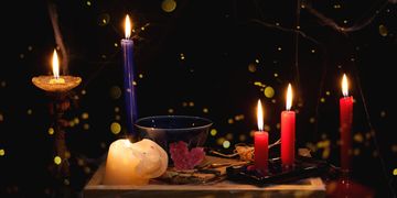A mystical arrangement of lit candles casting a warm glow in darkness.