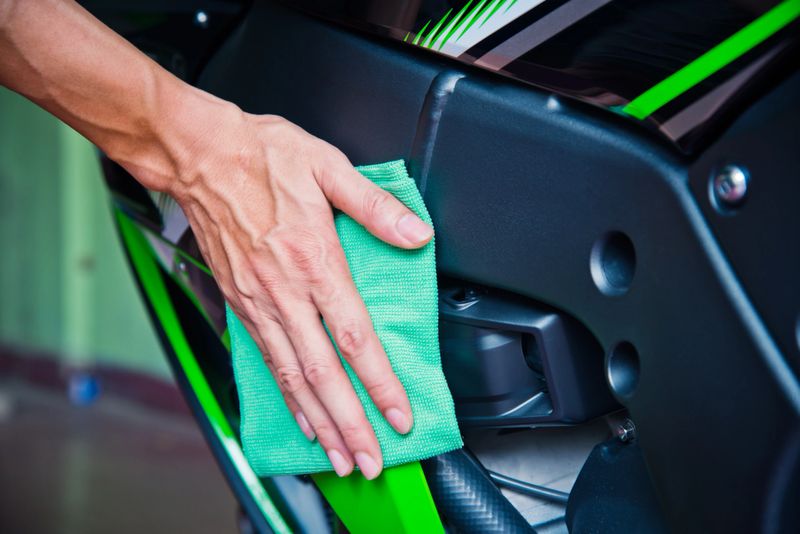 Cleaning motorcycle with green microfiber cloth