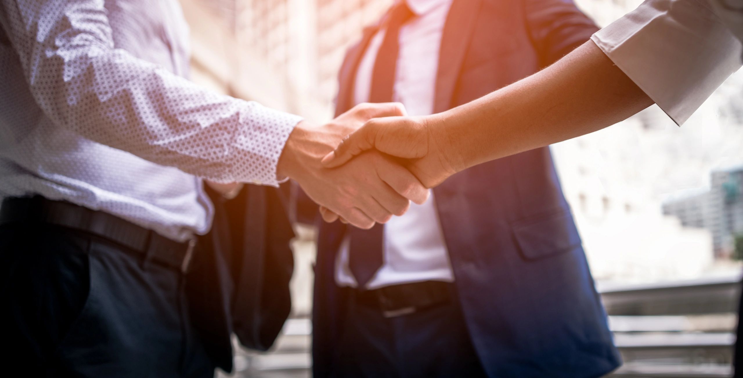 Two men shaking hands in a business setting.