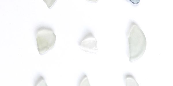 Scattered small translucent glass fragments on white background.