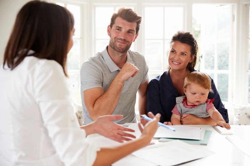 Family With Baby Meeting Financial Advisor At Home