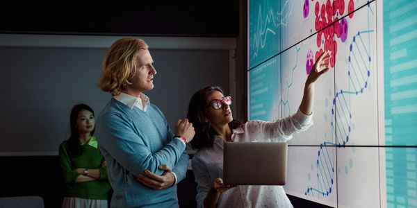 Smart looking people reviewing science DNA image on a whiteboard reviewing evidence.