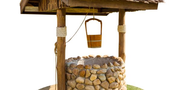 A rustic stone water well with a wooden bucket and roof.