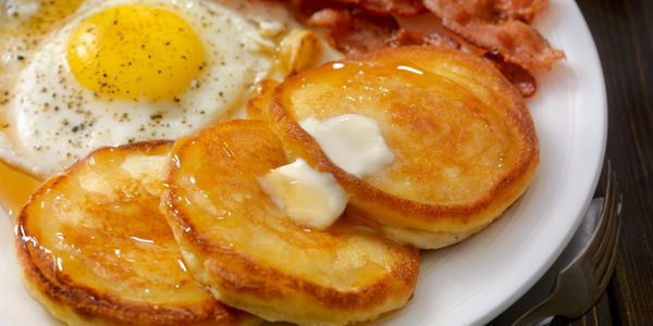 pancakes, eggs, and bacon breakfast on a plate