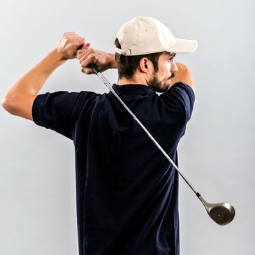 Man in a cap swinging a golf club.