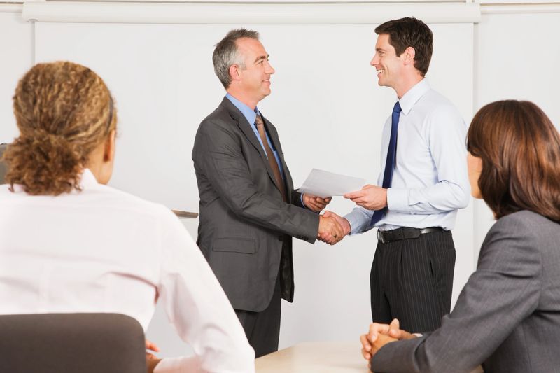 A lecturer handing a certificate to a student