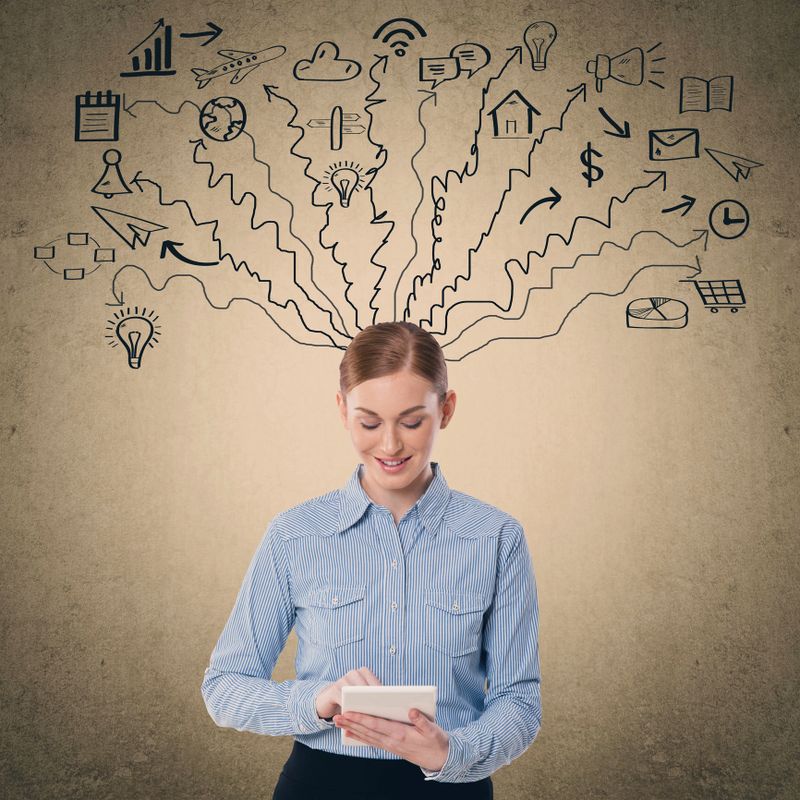 Businesswoman holding digital tablet and surprisingly looking at icons on wall