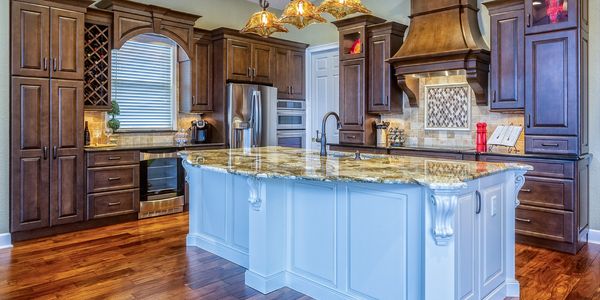 Elegant kitchen with dark wood cabinets and a large marble island.