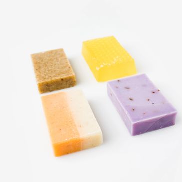 Four colorful rectangular soap bars arranged on a white surface.