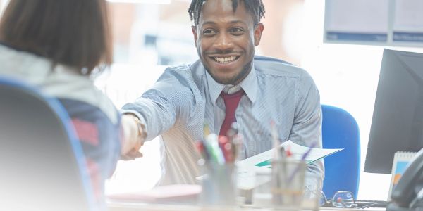Smiling man in office shaking hands during a meeting.