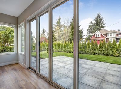 Salle avec portes vitrées donnant sur une terrasse et jardin.