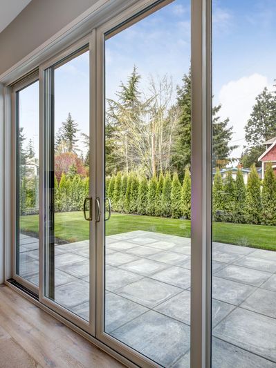 Grande porte-fenêtre coulissante avec vue sur jardin.