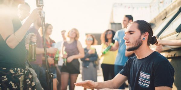 Young man playing music at a rooftop party.