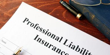 Professional liability insurance document with pen and glasses.