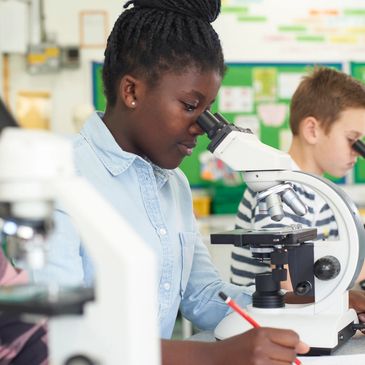 Student using a microscope in a science lab.