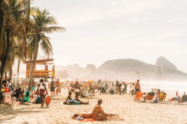 Playa soleada con muchas personas y palmeras.
