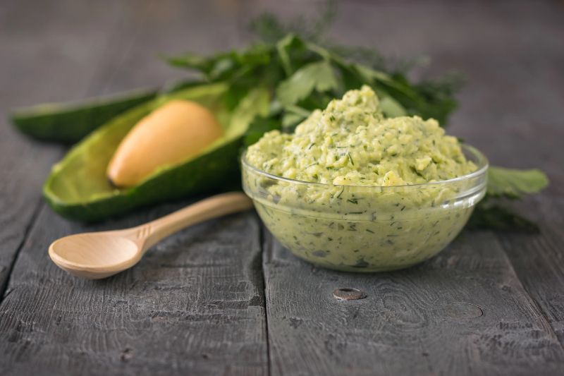 Cream puree avocado with parsley, dill and garlic in a bowl on a vintage table. The dish is vegetarian diet. Diet for weight loss.