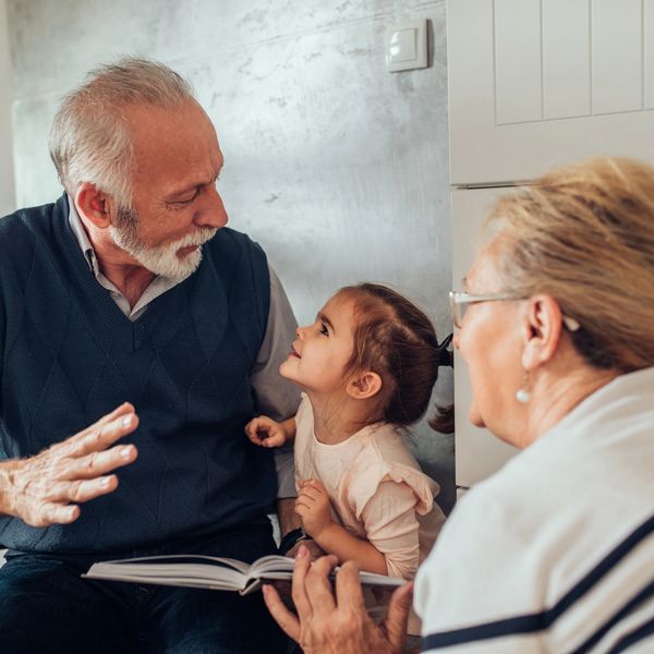 Grandparents reading to granddaughter.