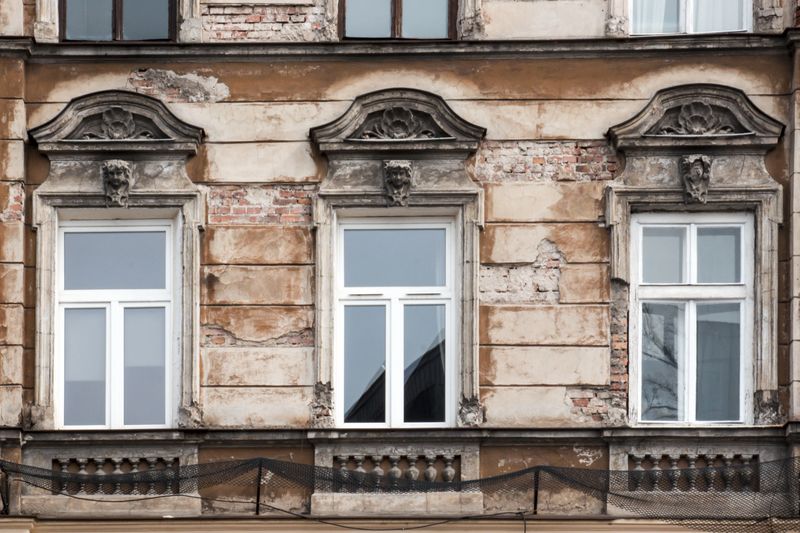 Three Windows on the facade of the old shabby house