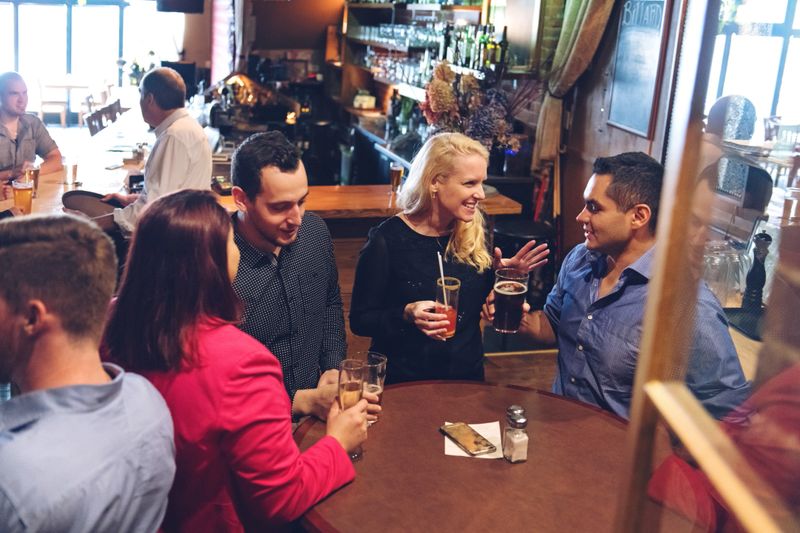 Coworkers having an happy hour in a bar, happy hour time