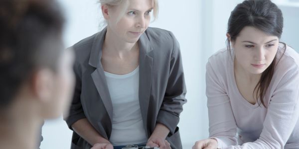 Woman holding clipboard in a serious meeting.