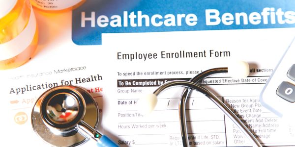 Healthcare forms with stethoscope and prescription bottles symbolizing medical benefits.