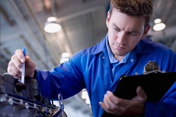 Mechanic performing advanced vehicle diagnostics in a garage. 