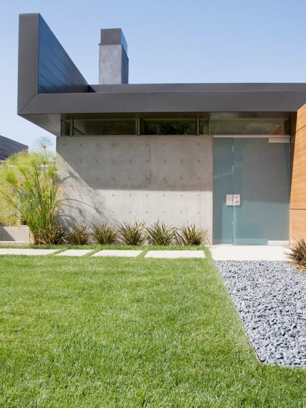 Modern house entrance with concrete walls and glass door.