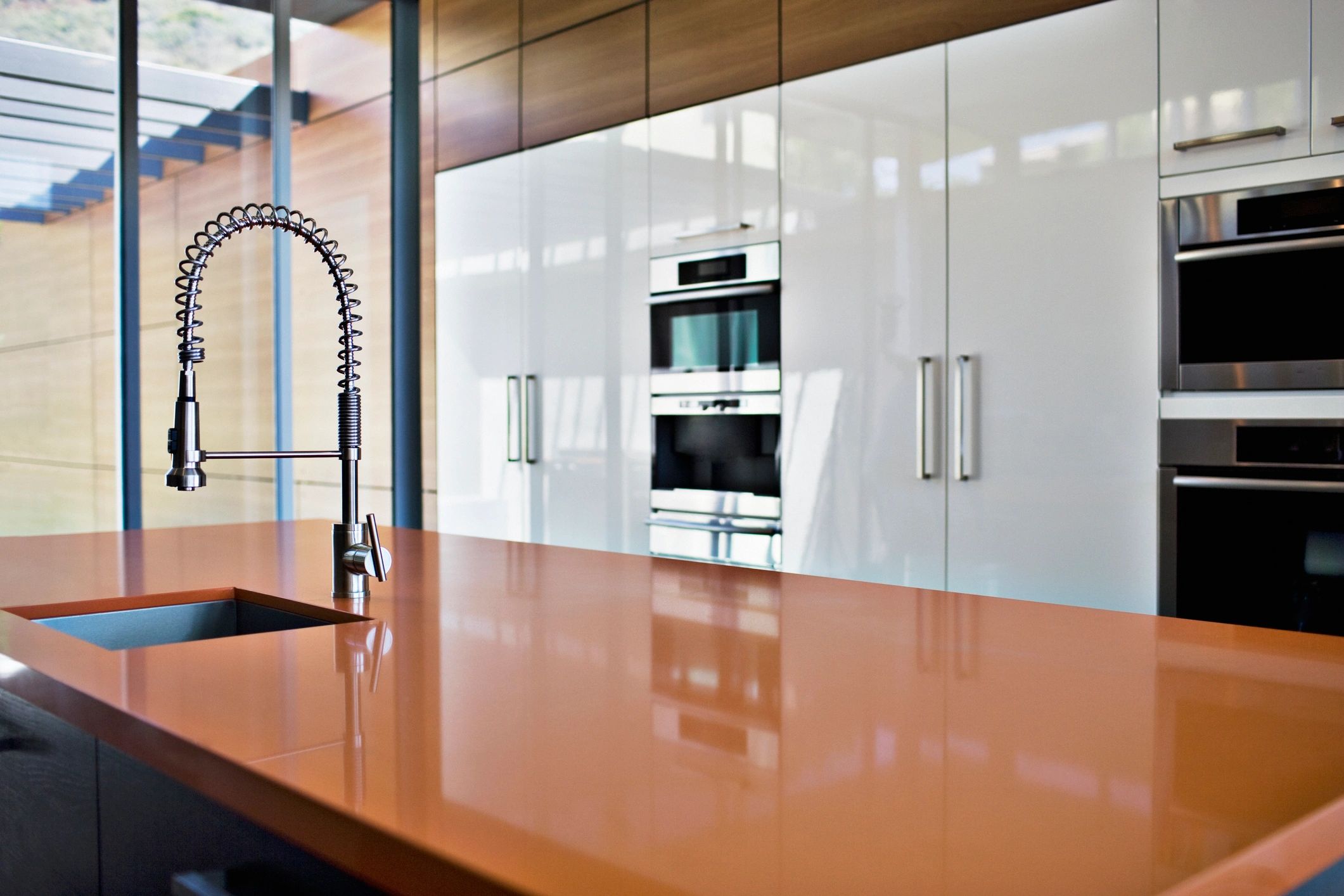 Modern kitchen with sleek cabinetry and a polished brown countertop.