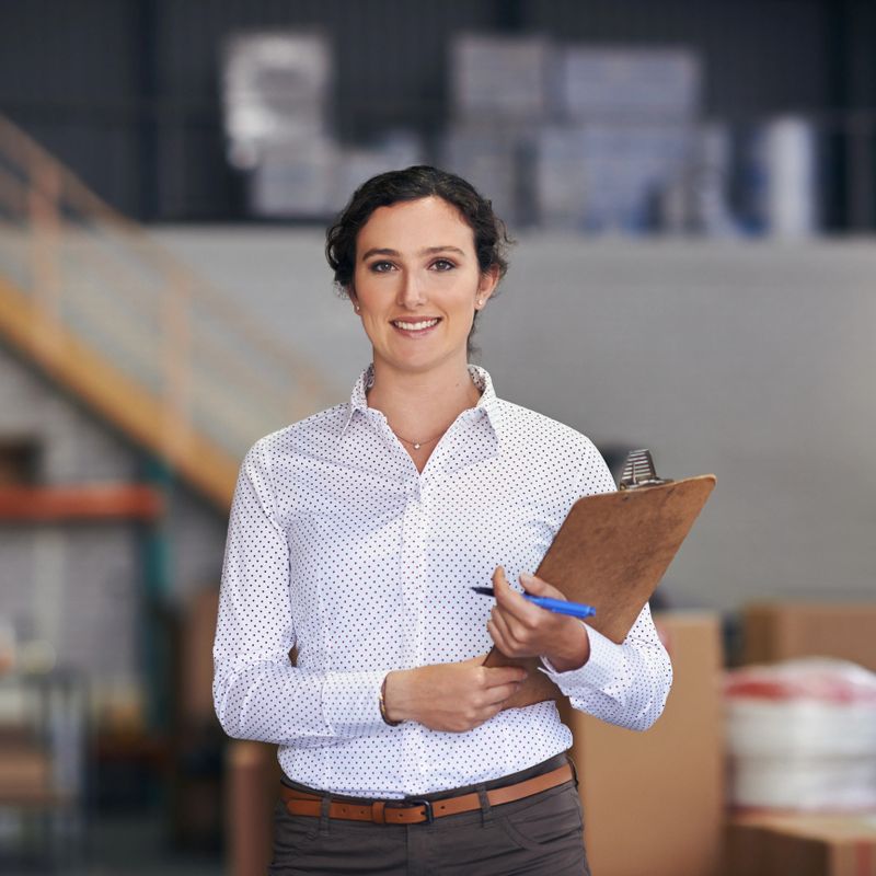 Cropped portrait of an attractive young female warehouse worker  using a clipboard to take stock