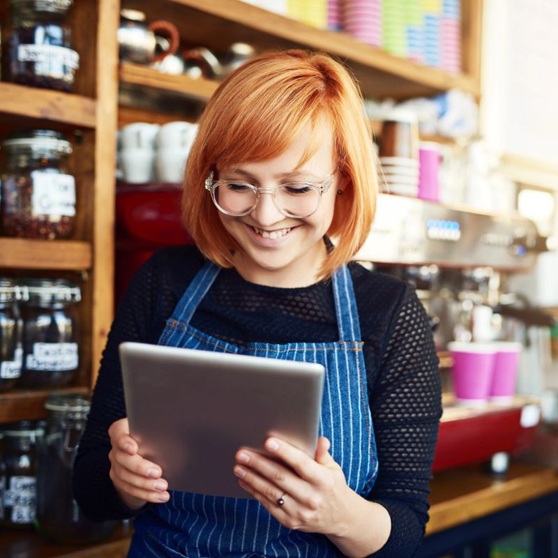 Shot of a young woman using a digital tablet while working in a coffee shop