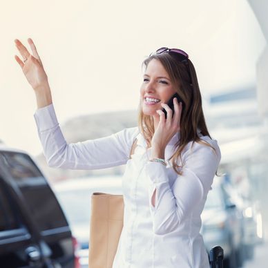 Smiling woman talking on phone and waving.