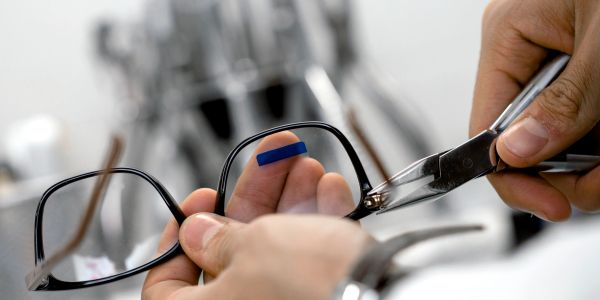 Repairing eyeglasses using a tool.