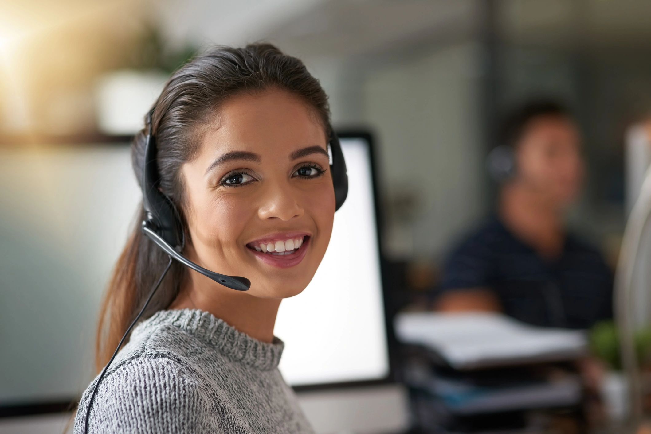 Smiling woman in headset at customer service.