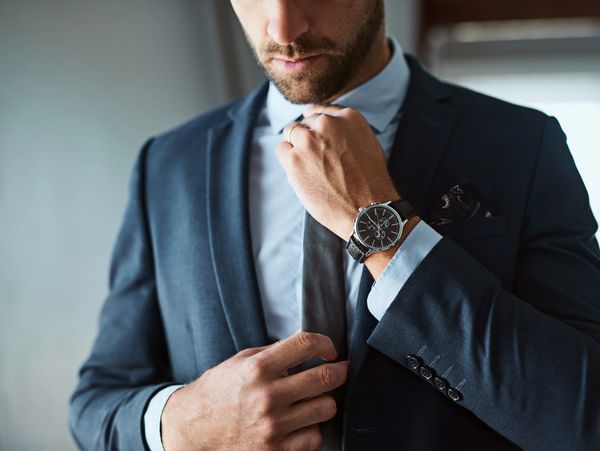 Man adjusting his blue suit.