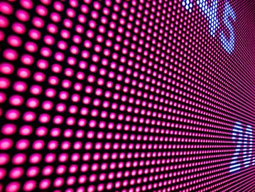 Close-up of a bright pink LED display screen with partial white text.