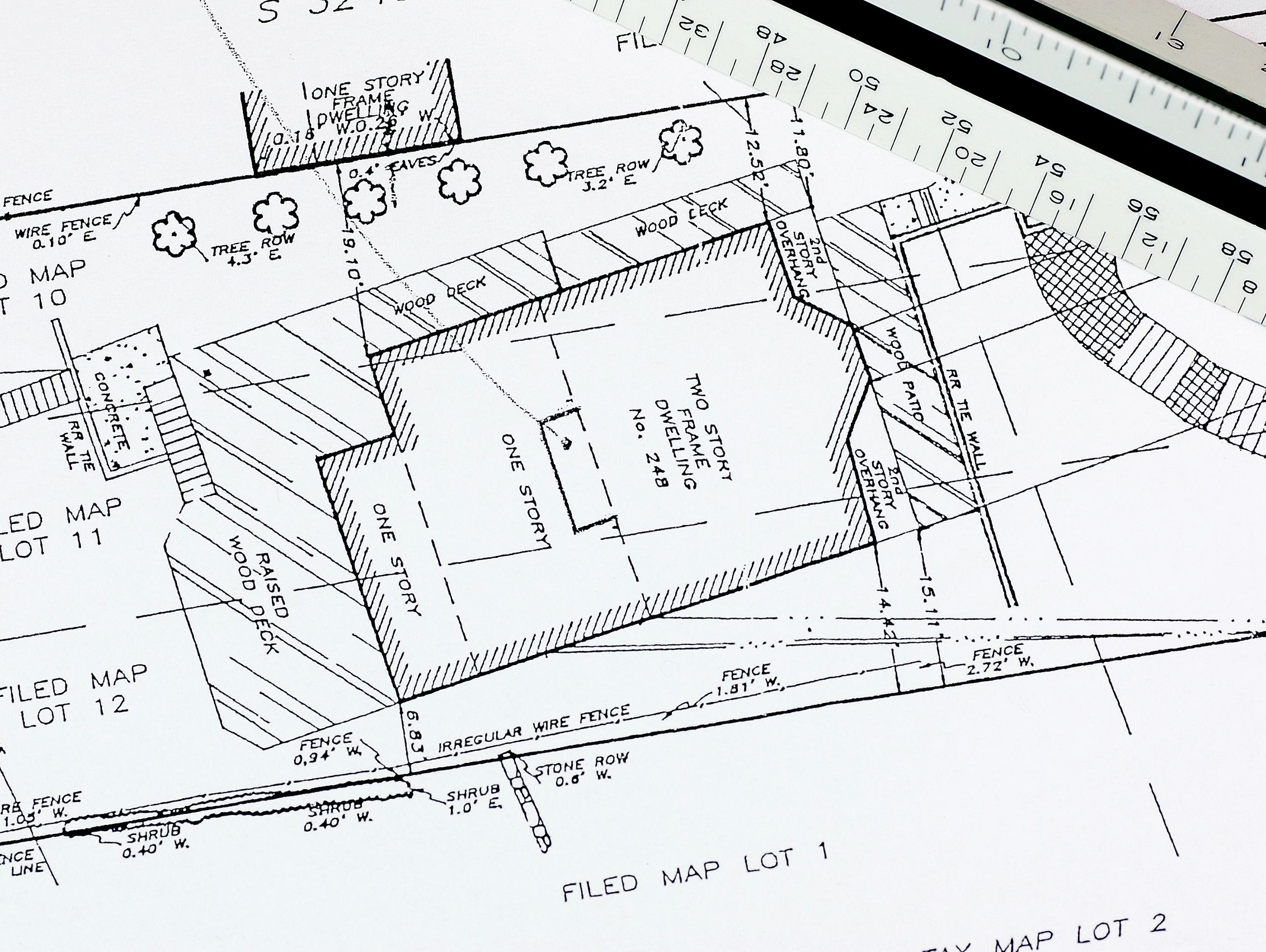 Architectural site plan showing lot boundaries and building details with a scale ruler.