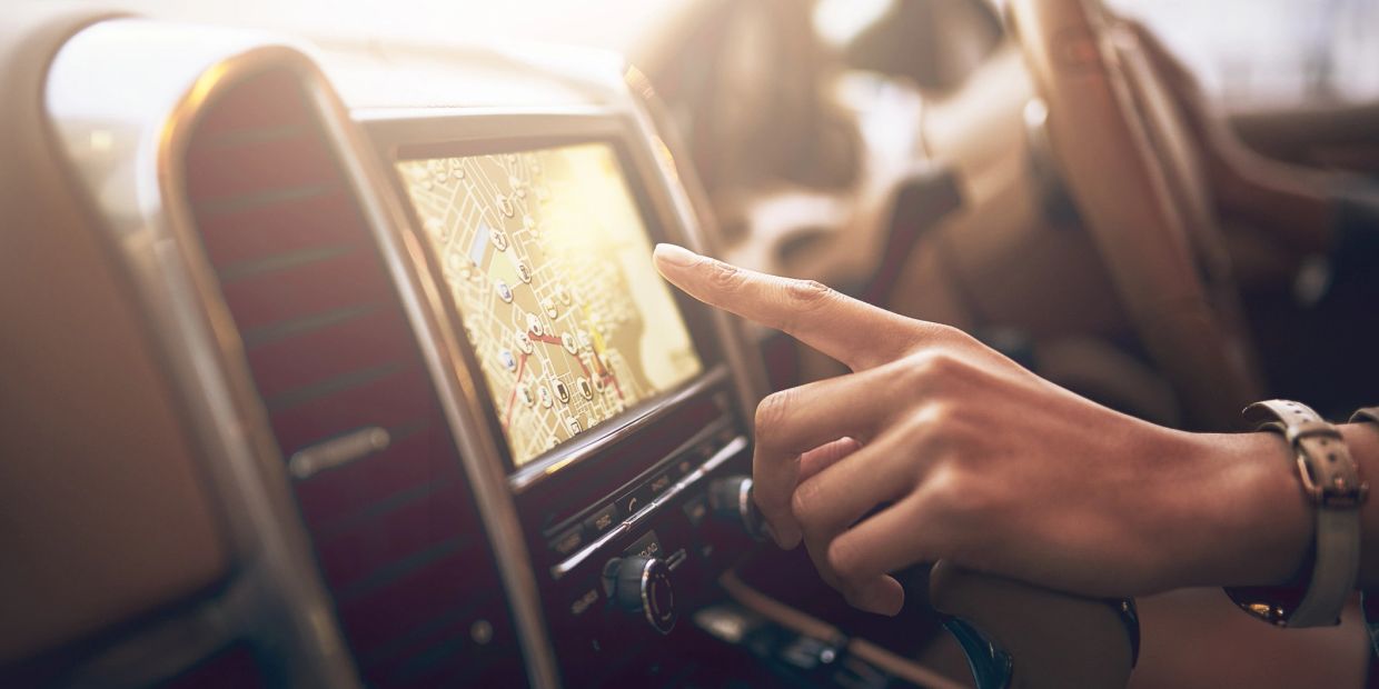 Hand using car GPS navigation system.