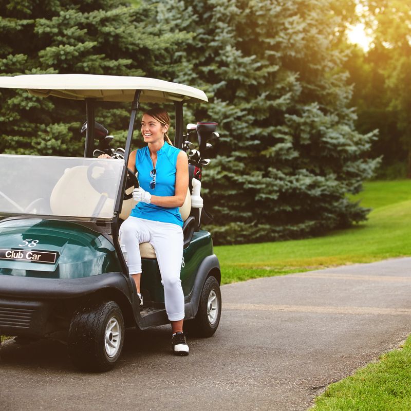 Full length shot of an attractive young woman sitting in a golf cart on a golf course