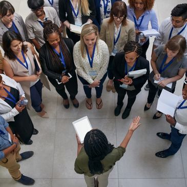 A professional addressing a diverse group in a meeting circle.