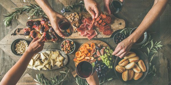Friends gathering over a charcuterie board.