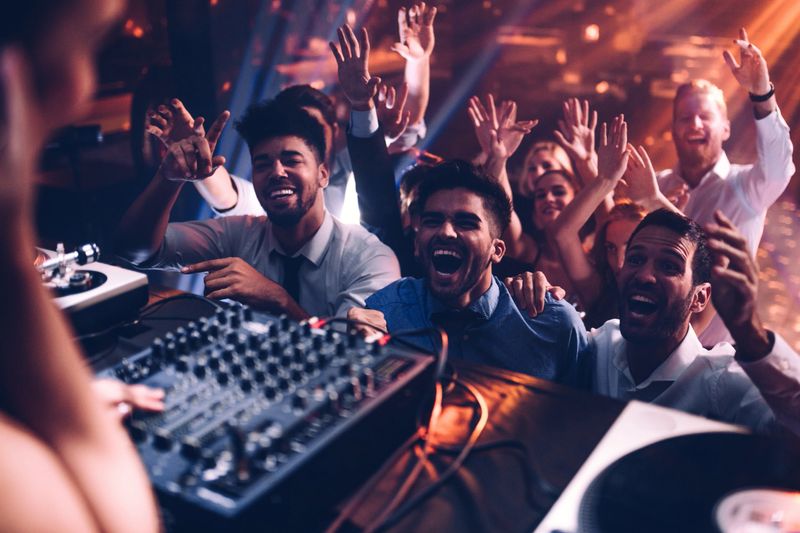 Group of people cheering in front of the DJ