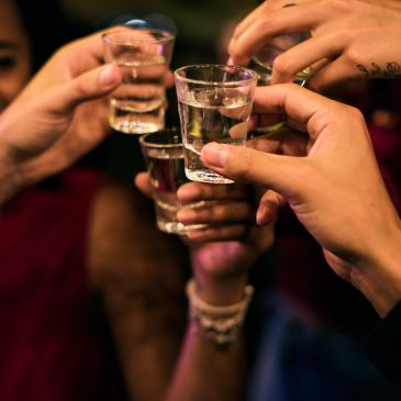 Personas brindando con shots de licor.