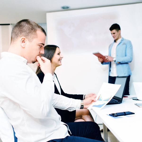 Personas en una reunión de trabajo con gráficos y presentación.