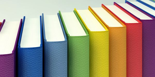 A row of colorful books with textured covers arranged in a gradient pattern.