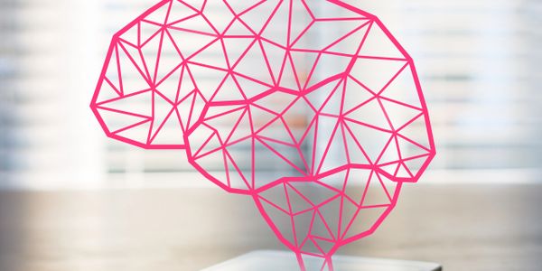 Digital brain hologram emerging from a smartphone on a table.